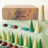 Grapat x Ostheimer Hrókur Mandala Pieces Set Wooden Toy placed on green Ostheimer cotton scarf besides the box.