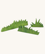 Ostheimer green wooden grass figures on a plain background. There a 3 grass pieces in the set, small, medium and large lengths. 