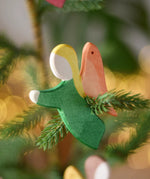 Ostheimer green angel wooden handmade decoration placed on a Christmas tree branch. 