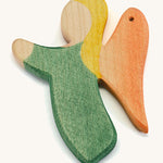 A green wooden angel figure on a cream background