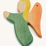 A green wooden angel figure on a cream background