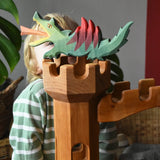 Ostheimer green dragon handmade wooden toy figure toy placed on top of the castle tower.