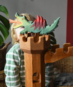 Ostheimer green dragon handmade wooden toy figure toy placed on top of the castle tower.