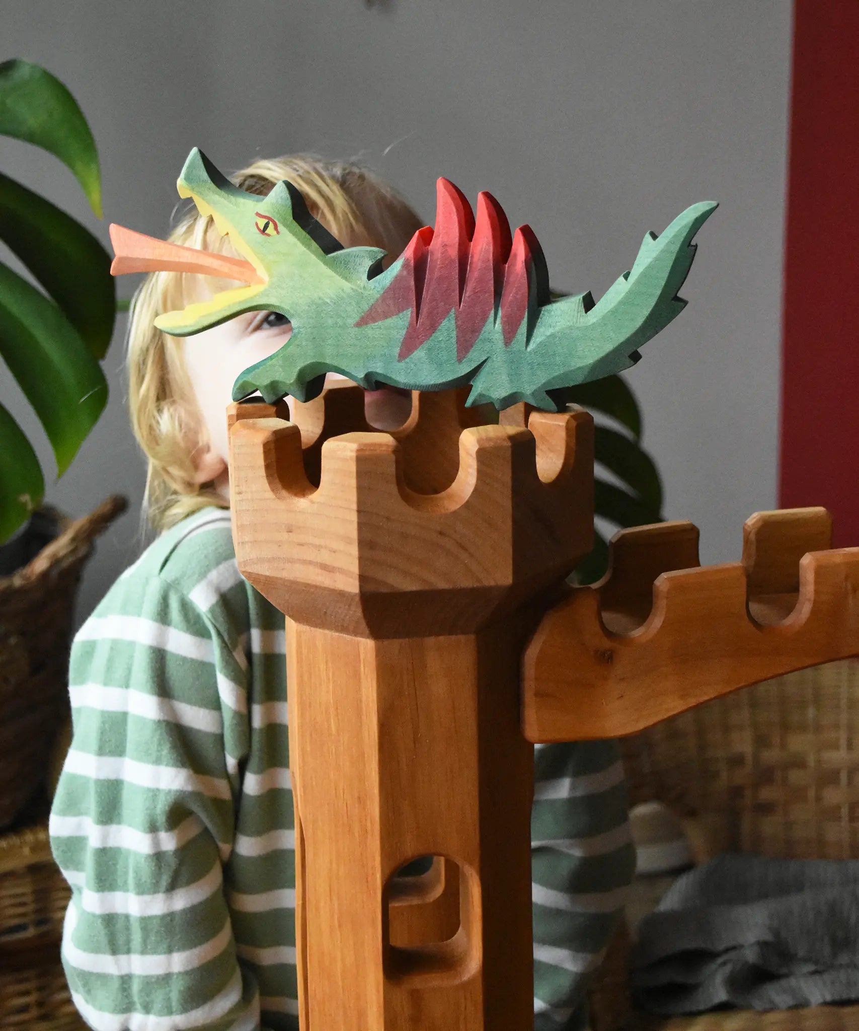 Ostheimer green dragon handmade wooden toy figure toy placed on top of the castle tower.