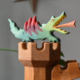 Ostheimer dragon handmade wooden toy figure toy placed on top of the castle tower.