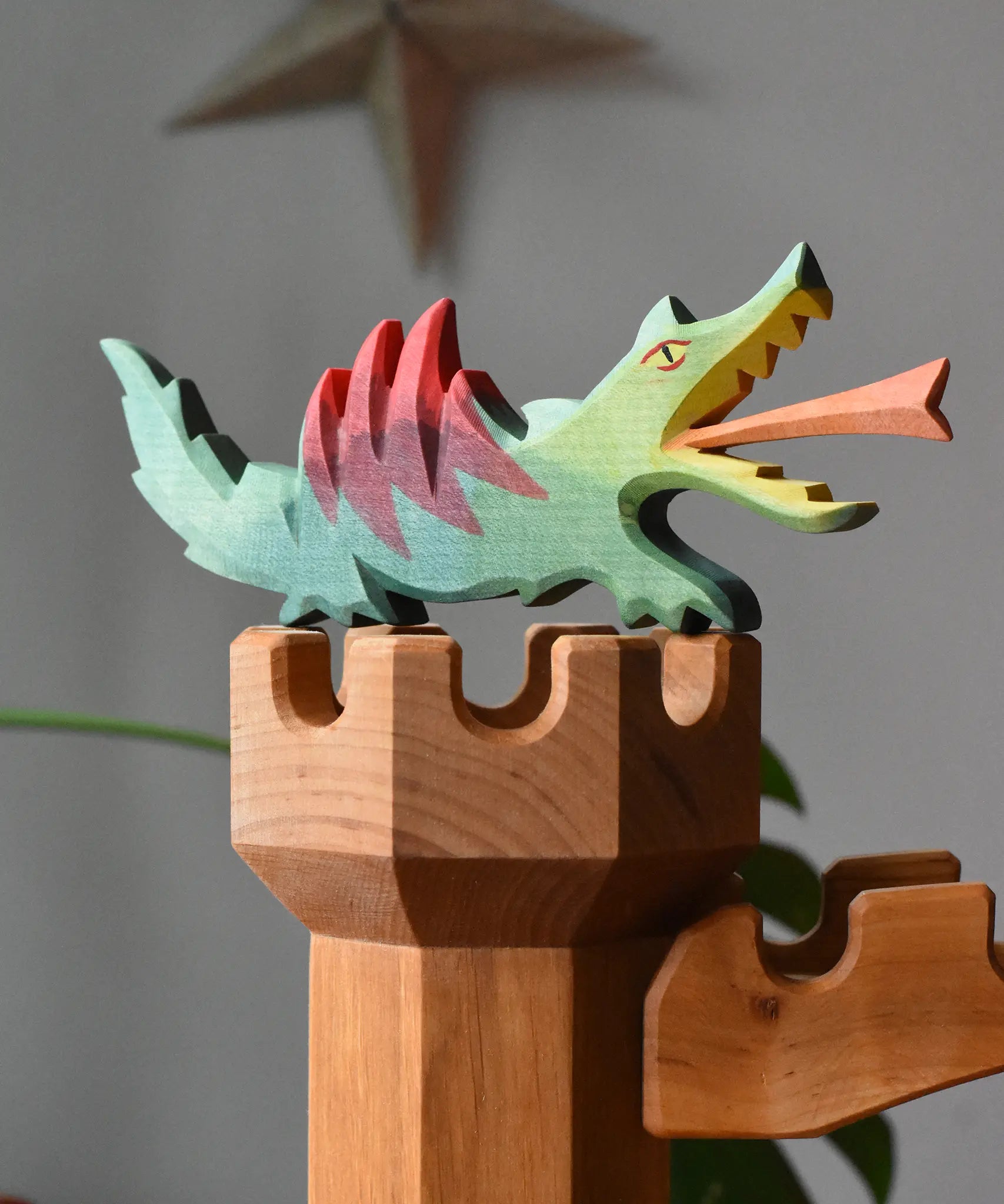 Ostheimer dragon handmade wooden toy figure toy placed on top of the castle tower.