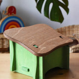 Back of the Ostheimer green hutch for toy animals placed on a wooden surface with Babipur toys in the background. 