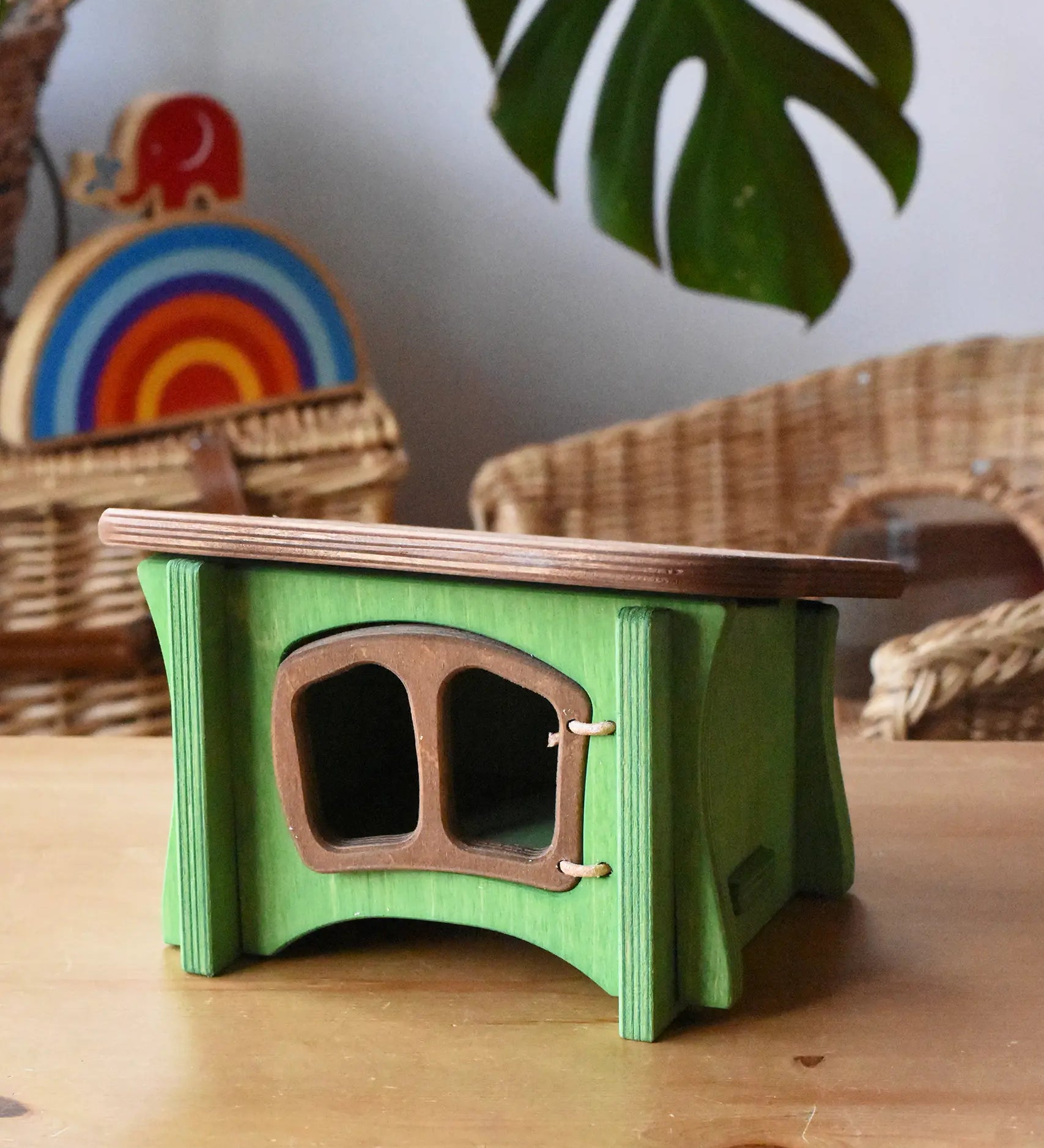 Ostheimer green hutch for toy animals placed on a wooden surface with Babipur toys in the background.
