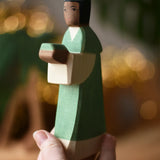 Ostheimer green king wooden toy figure in a child's hand. 