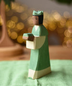 Ostheimer green king wooden toy figure placed on a cotton green play cloth. 