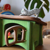 Ostheimer grey striped jumping car wooden toy figure placed on the roof the green hutch.
