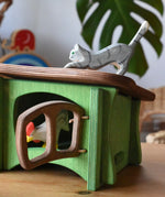 Ostheimer grey striped jumping car wooden toy figure placed on the roof the green hutch.