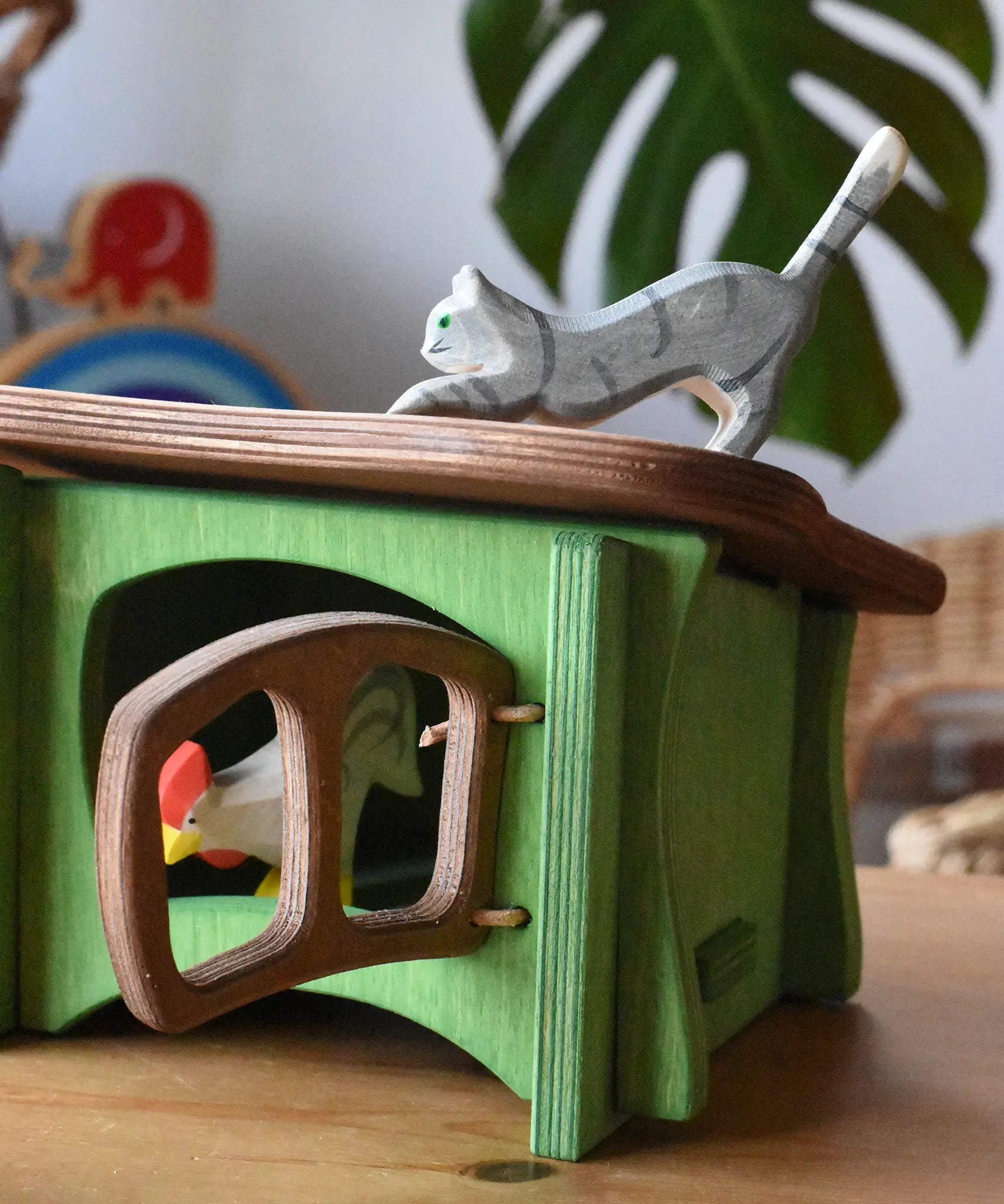 Ostheimer grey striped jumping car wooden toy figure placed on the roof the green hutch.