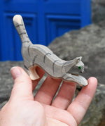 Ostheimer grey striped jumping car wooden toy figure in a child's hand.
