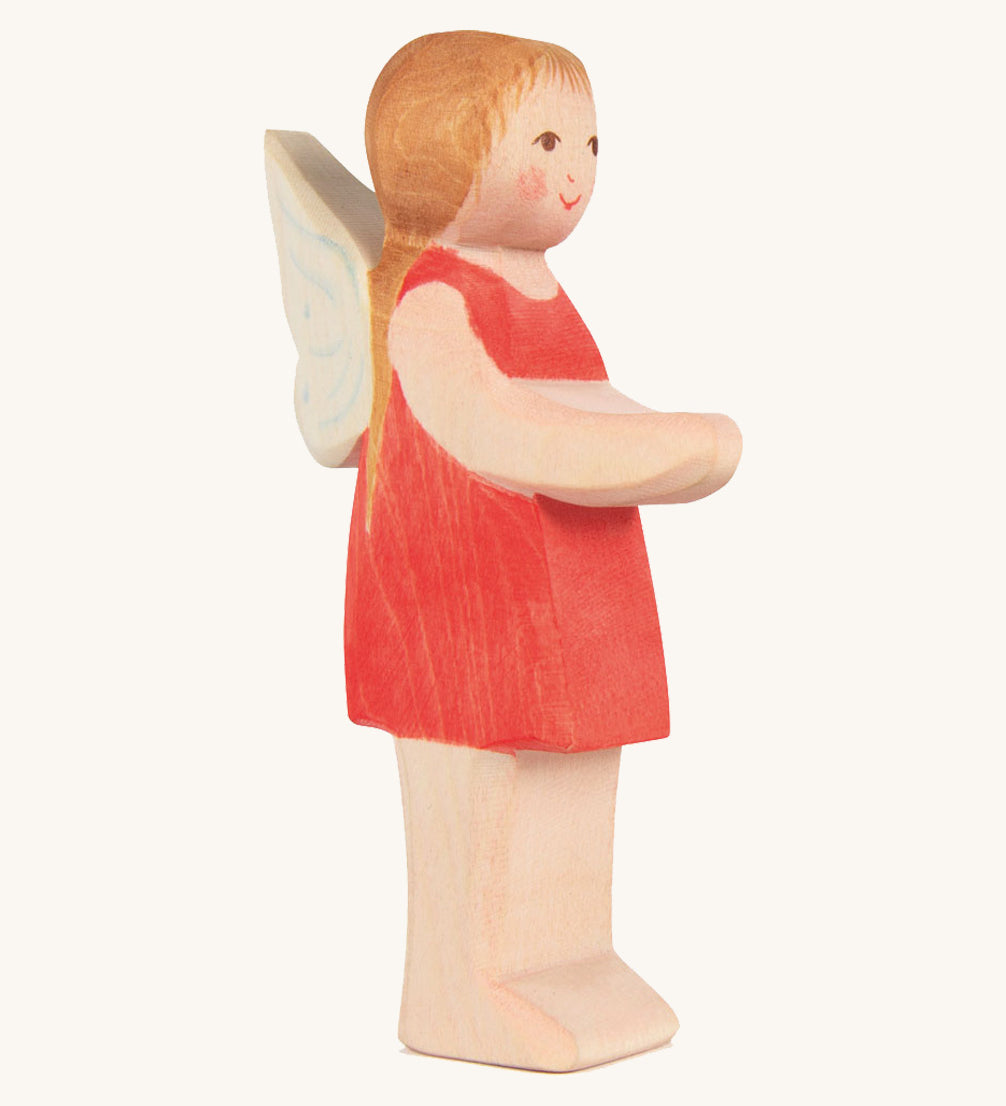 The Ostheimer hand made wooden 'Sumselinchen' character figure from the German story “Pepe and Sumselinchen”. She has a red dress, fairy wings, and long golden hair.