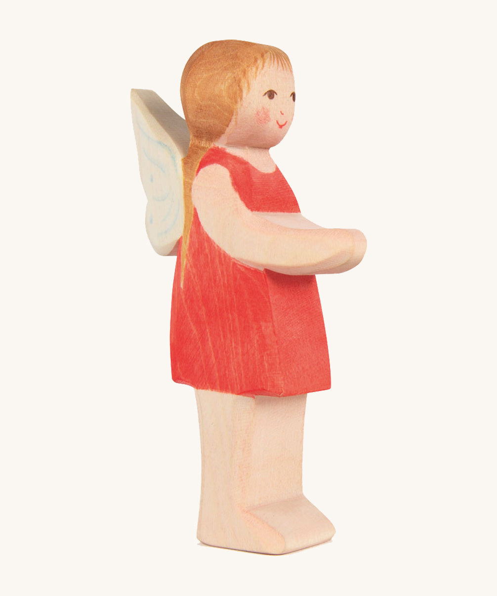 The Ostheimer hand made wooden 'Sumselinchen' character figure from the German story “Pepe and Sumselinchen”. She has a red dress, fairy wings, and long golden hair.