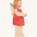 The Ostheimer hand made wooden 'Sumselinchen' character figure from the German story “Pepe and Sumselinchen”. She has a red dress, fairy wings, and long golden hair.