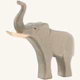 The Osheimer male elephant wooden toy, with large tusks and a trunk pointing upwards as if trumpeting.