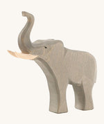 The Osheimer male elephant wooden toy, with large tusks and a trunk pointing upwards as if trumpeting.