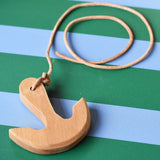 Ostheimer wooden anchor on string placed on a blue and green striped tray.