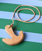 Ostheimer wooden anchor on string placed on a blue and green striped tray.