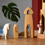 Small world play scene featuring a selection of Ostheimer handmade wooden toys and figures. Female farmer, horse with blue saddle, sentry post with bell, princess, frog king and castle round tower with stairs.