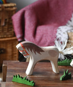Ostheimer wooden white horse for rider toy figure placed at the front of a small world play scene with green grass scenery pieces. 