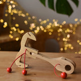 Ostheimer wooden toy horse harness accessory placed on a wooden surface. 