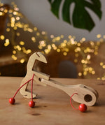 Ostheimer wooden toy horse harness accessory placed on a wooden surface. 