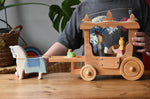 Ostheimer wooden white horse with saddle placed at the front of the stage coach with the rope attachment around it's front. Medieval and frog prince princesses are inside the coach.