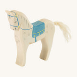 A white wooden horse figure with a blue saddle on a cream background