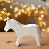 Ostheimer horse paint your own wooden figure placed on a wooden surface. 