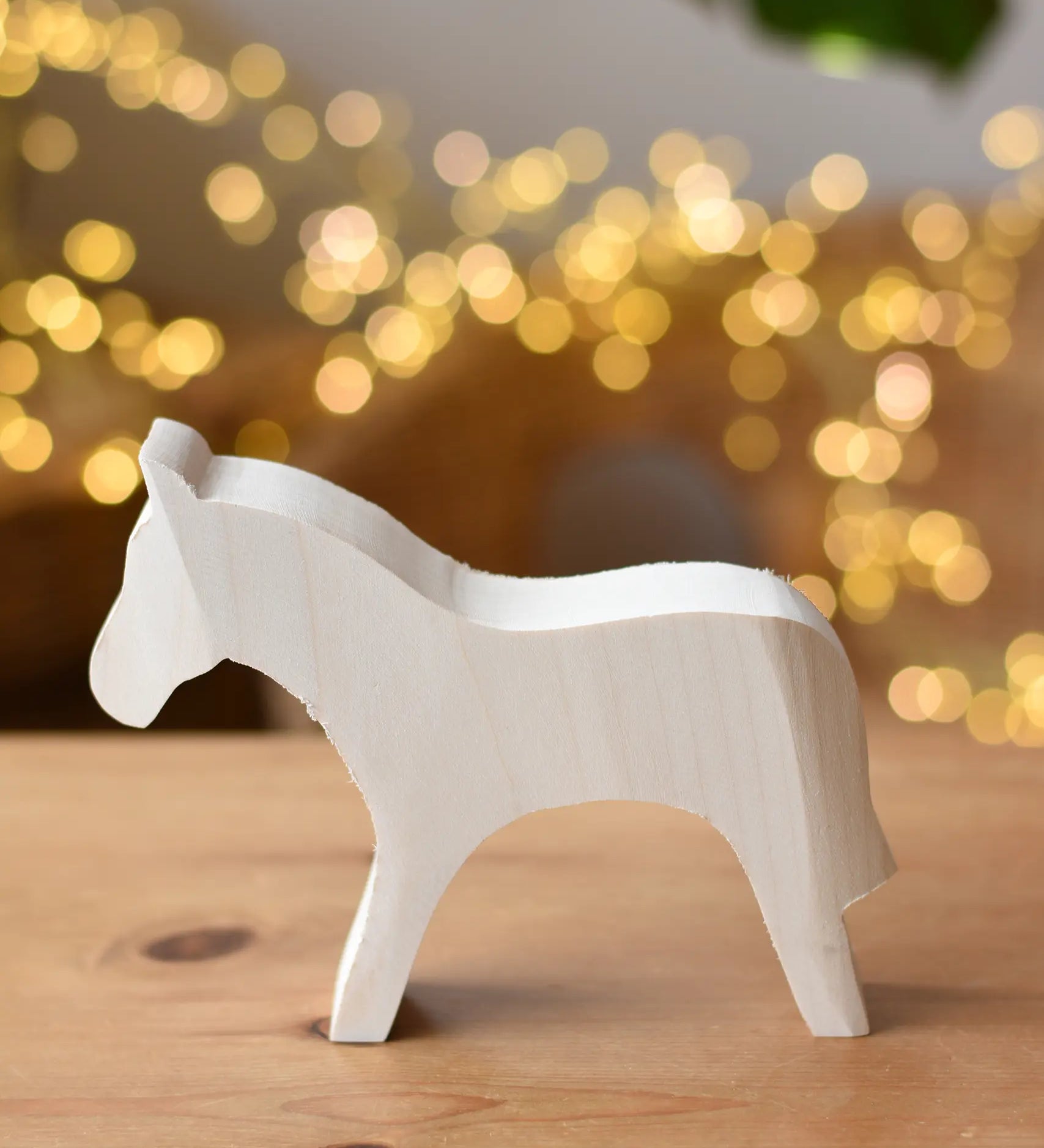 Ostheimer horse paint your own wooden figure placed on a wooden surface. 