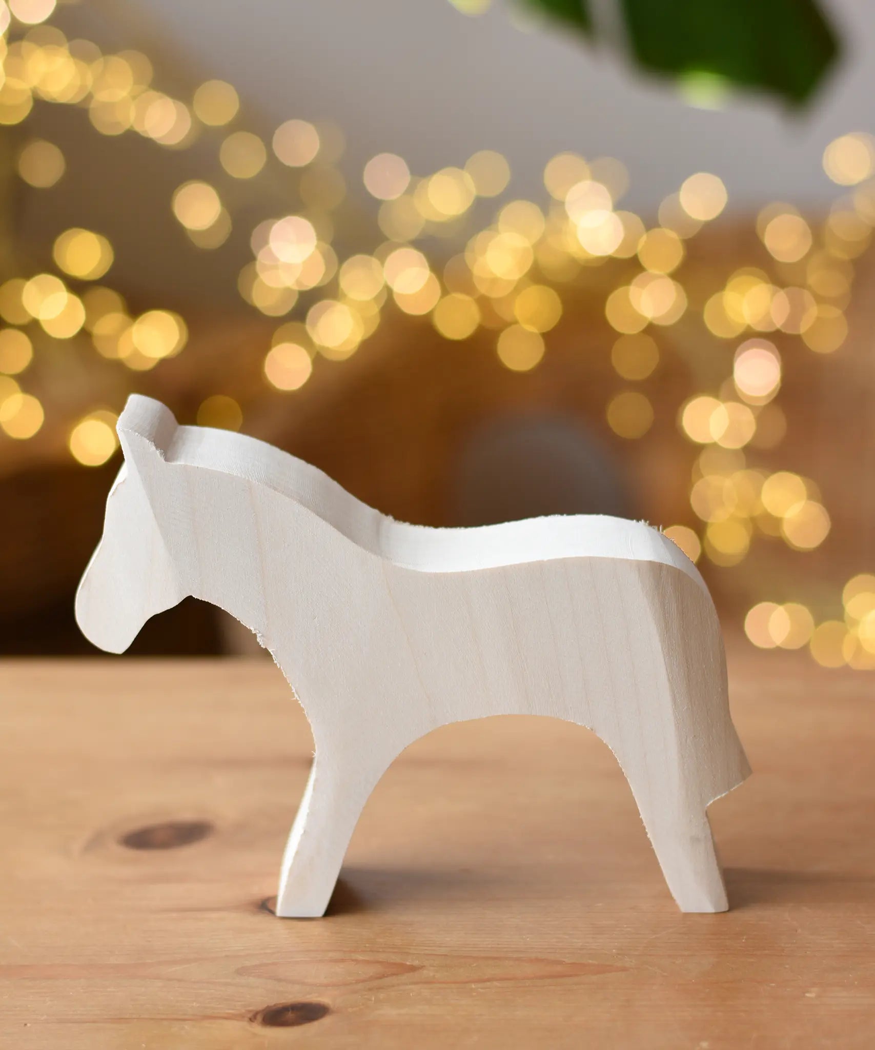 Ostheimer horse paint your own wooden figure placed on a wooden surface. 