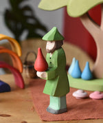 Ostheimer hunter wooden toy figure person with a green outfit with a red fire drop Grapat mandala piece balance on it's hands. 