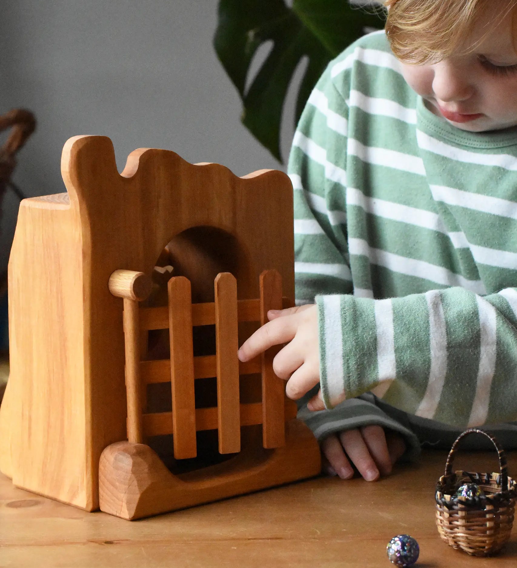 Ostheimer jailhouse wooden toy played with by a child opening the gate.