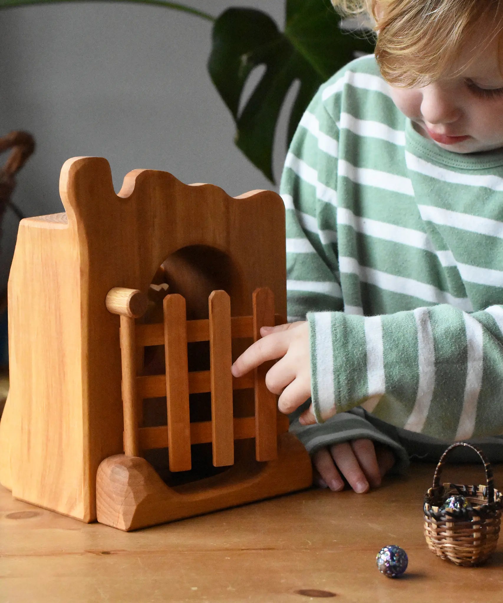 Ostheimer jailhouse wooden toy played with by a child opening the gate.