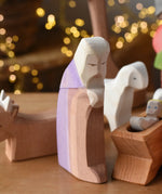Ostheimer Joseph handmade wooden toy figure placed in the front of a small world nativity themed play scene. 