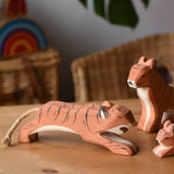 Ostheimer jumping tiger wooden toy figure placed on a wooden surface.