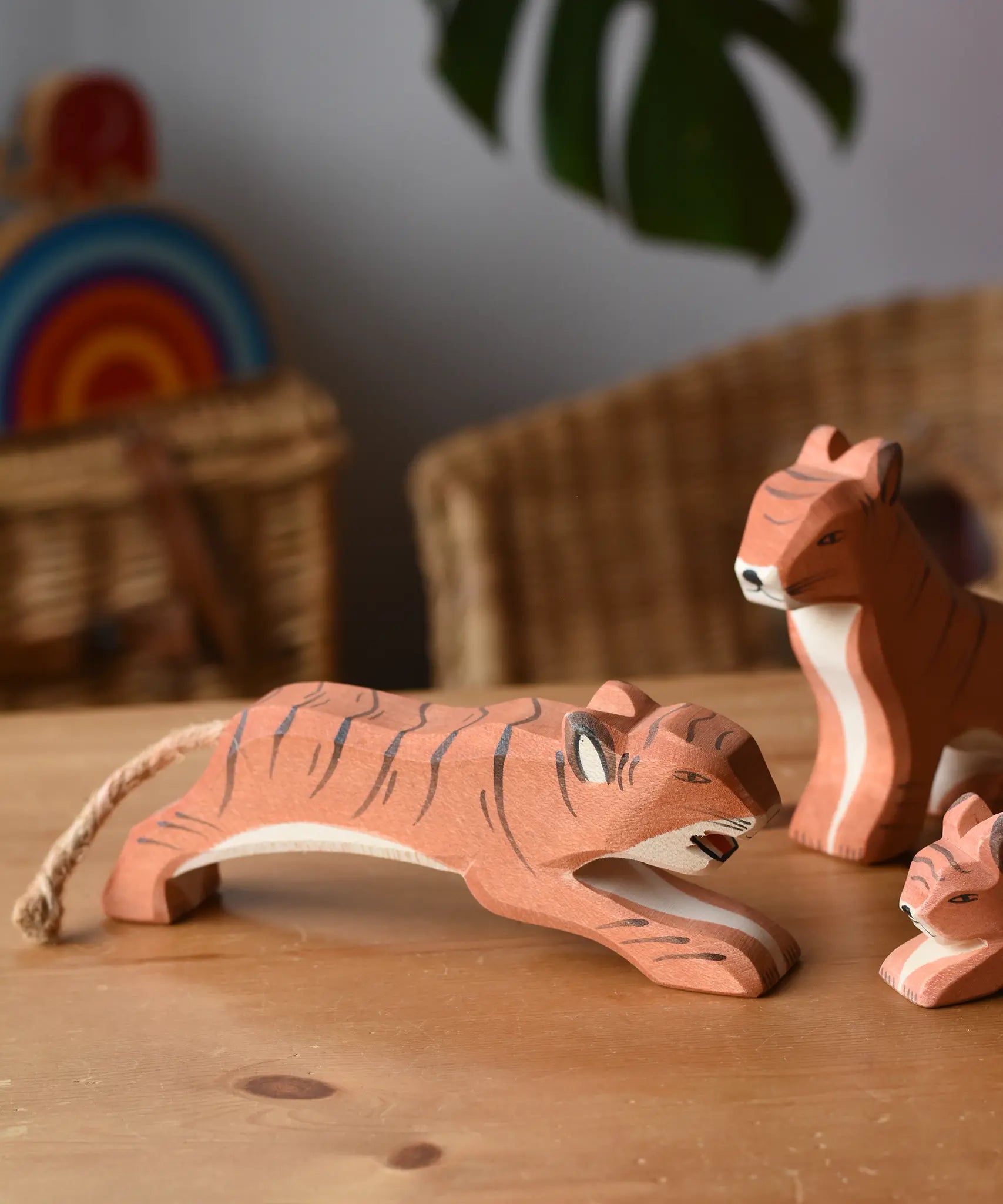 Ostheimer jumping tiger wooden toy figure placed on a wooden surface.