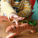 Ostheimer jumping tiger wooden toy figure with a child's hand reaching for it.