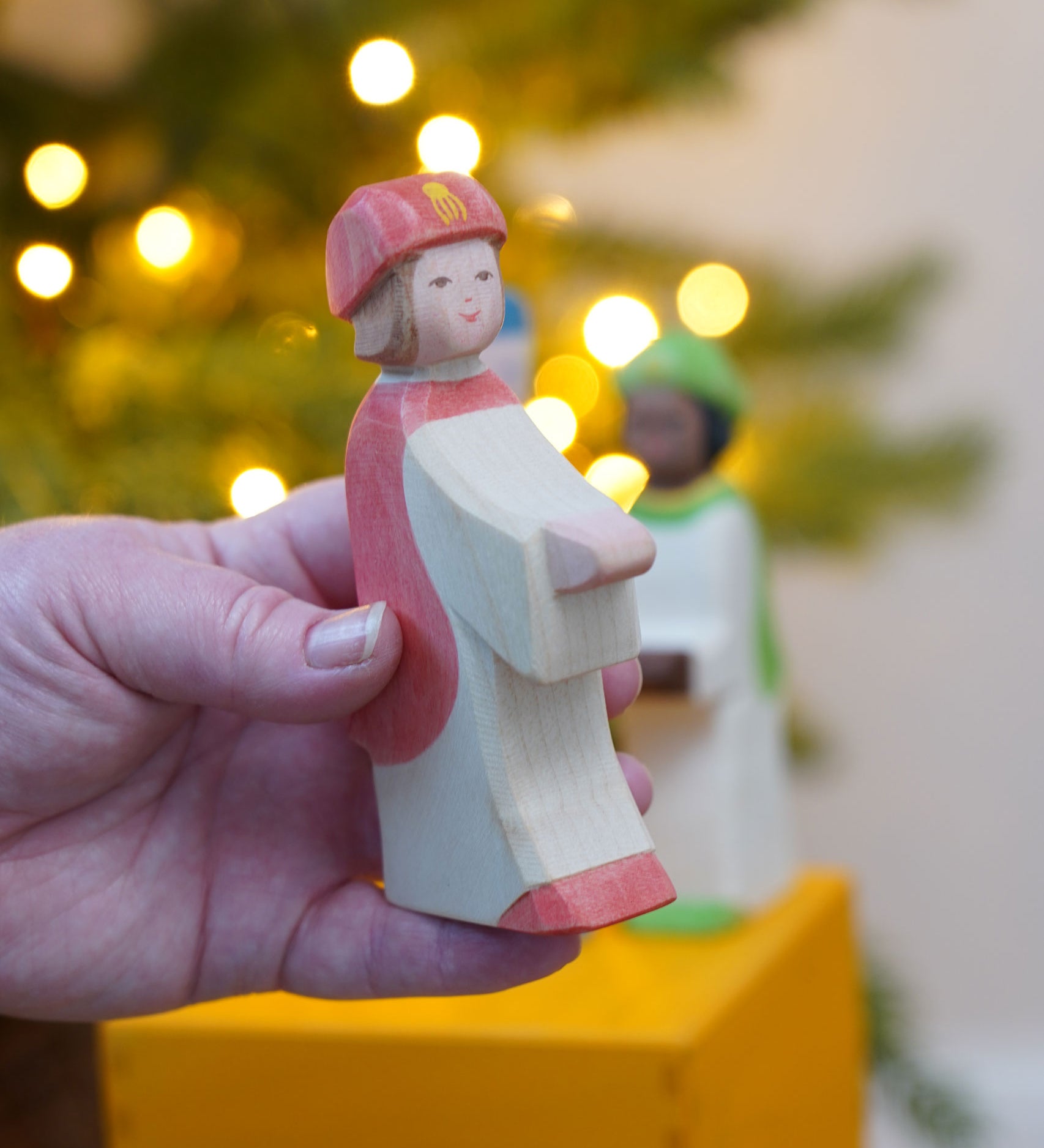 The Ostheimer Red King's Page  Three Wise Men Wooden Nativity Figure in an adult's hand. These wooden figures are part of a wide range of expertly hand crafted wooden toys here at Babipur. 