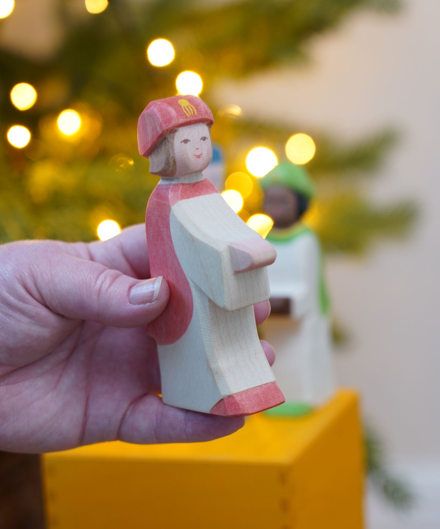 The Ostheimer Red King's Page  Three Wise Men Wooden Nativity Figure in an adult's hand. These wooden figures are part of a wide range of expertly hand crafted wooden toys here at Babipur. 