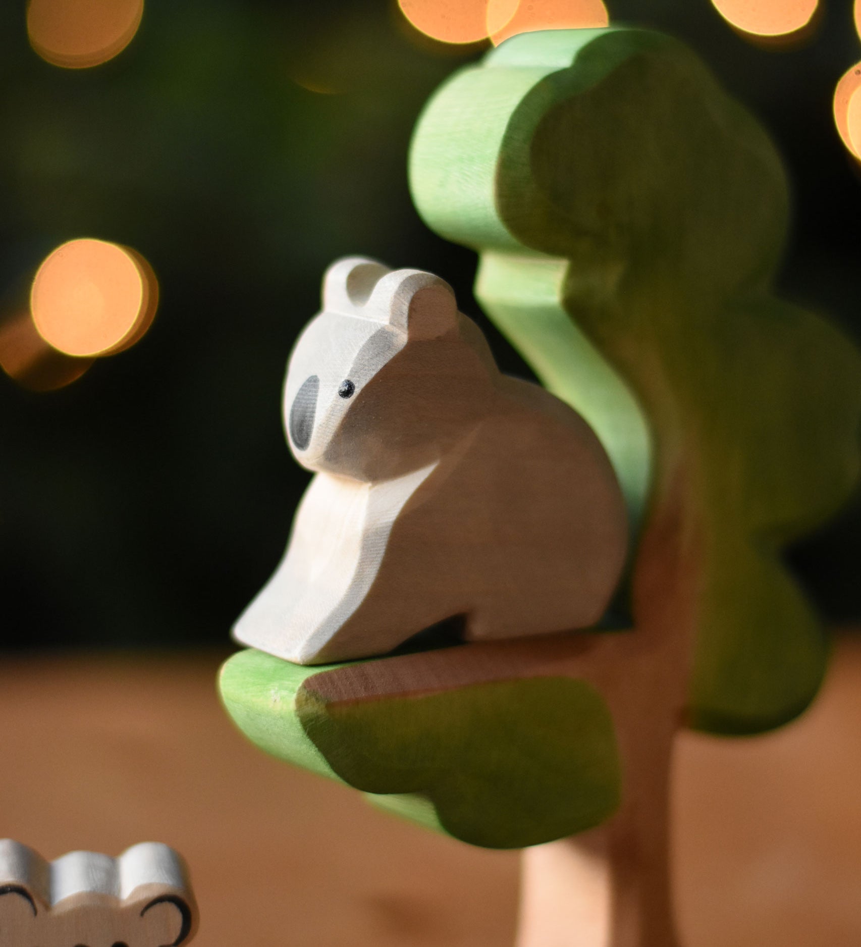 An Ostheimer sitting Koala figure placed on the eucalyptus tree wooden toy. 