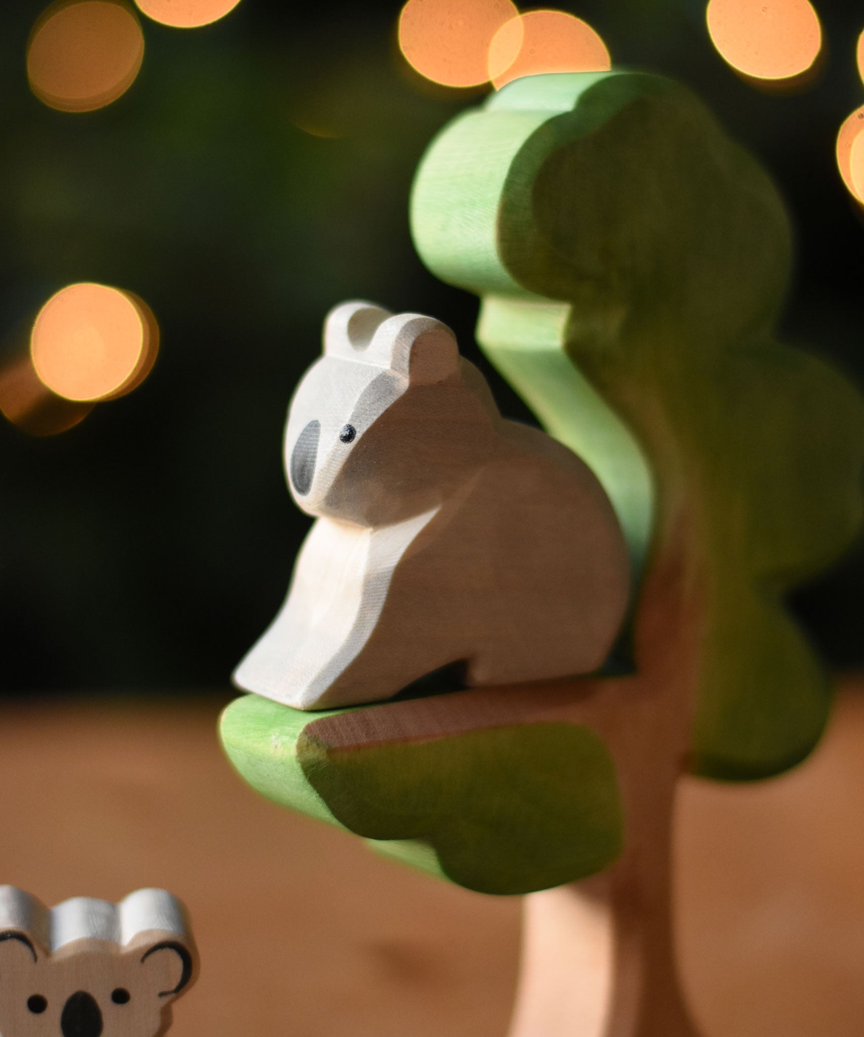 An Ostheimer sitting Koala figure placed on the eucalyptus tree wooden toy. 