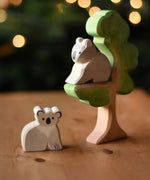 An Ostheimer sitting koala and koala wooden toy figures placed on and under the Ostheimer eucalyptus tree. These wooden figures are part of a wide range of expertly hand crafted wooden toys here at Babipur. 