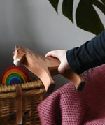 Close up of a Ostheimer brown horse wooden toy figure in a child's hand.