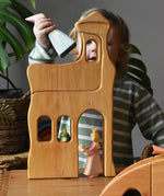 Ostheimer large wooden lookout tower wooden toy placed in a small world play scene with princess and frog king with a child placing a medival princess in the top tower.