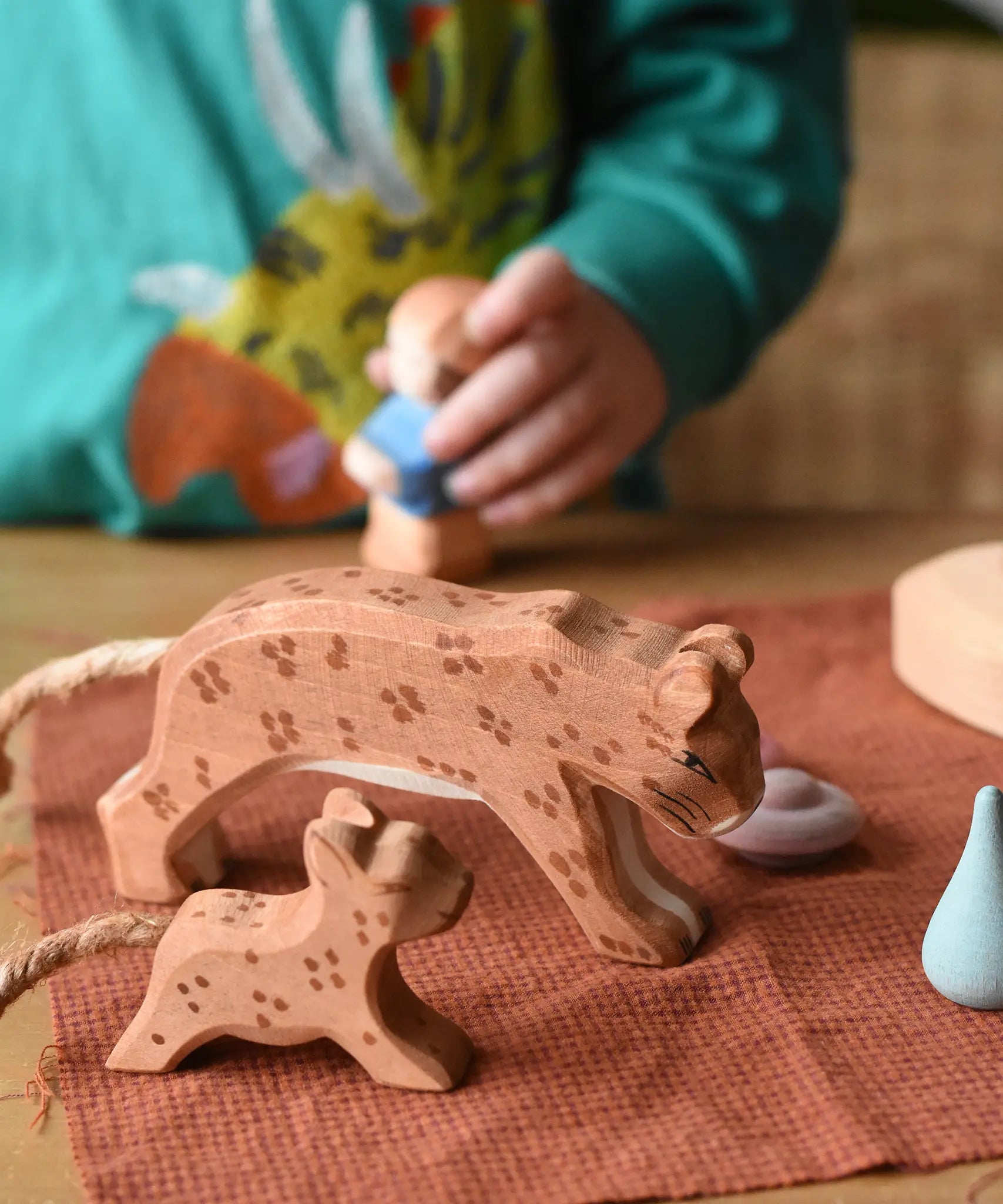 Ostheimer adult and small running leopard placed on a brown cloth in a small world play set up.