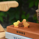 Ostheimer light chick and duckling placed next to each other on top of a pile of books.